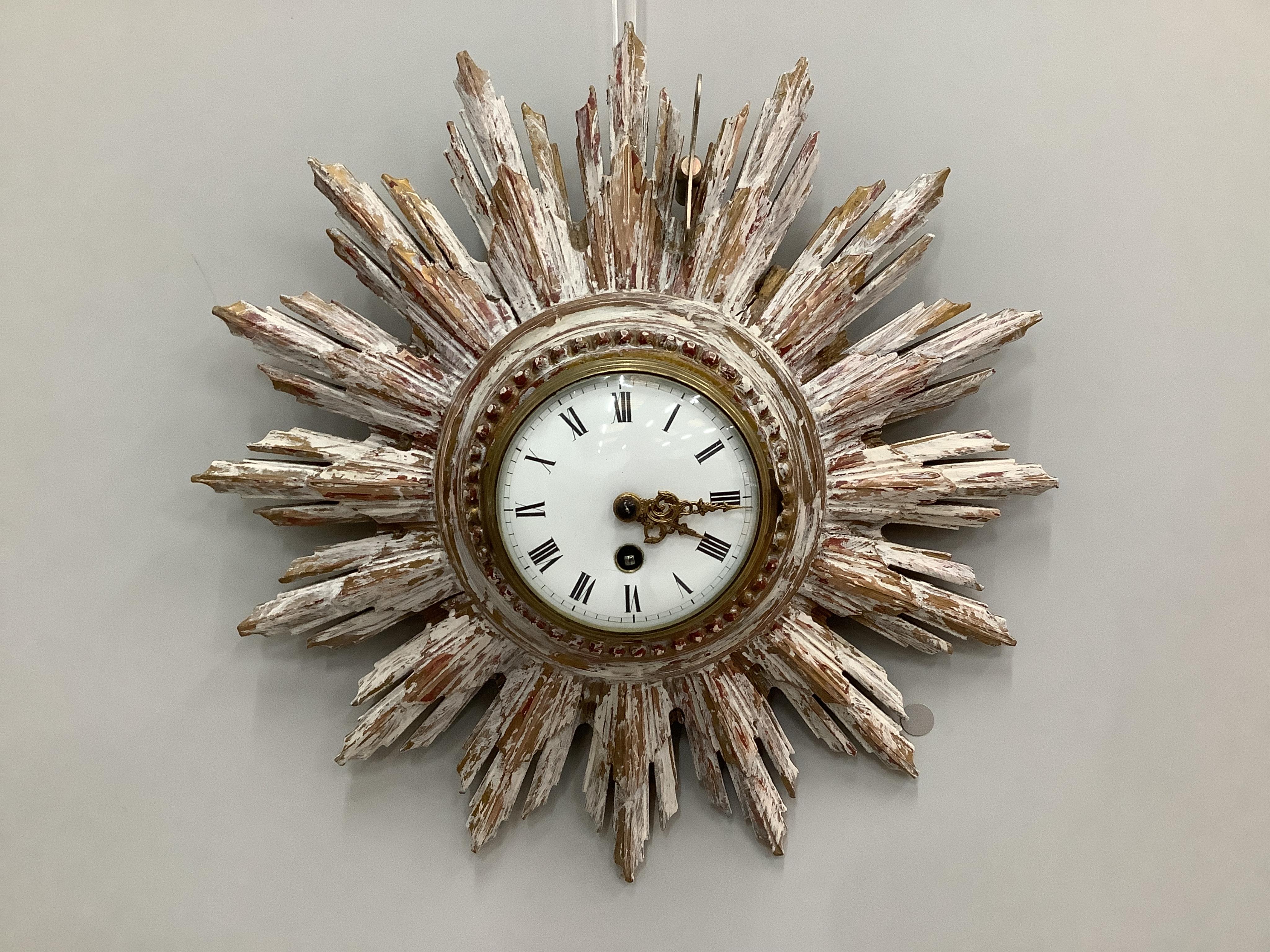 A carved wood cream painted sunburst wall timepiece, diameter 38cm